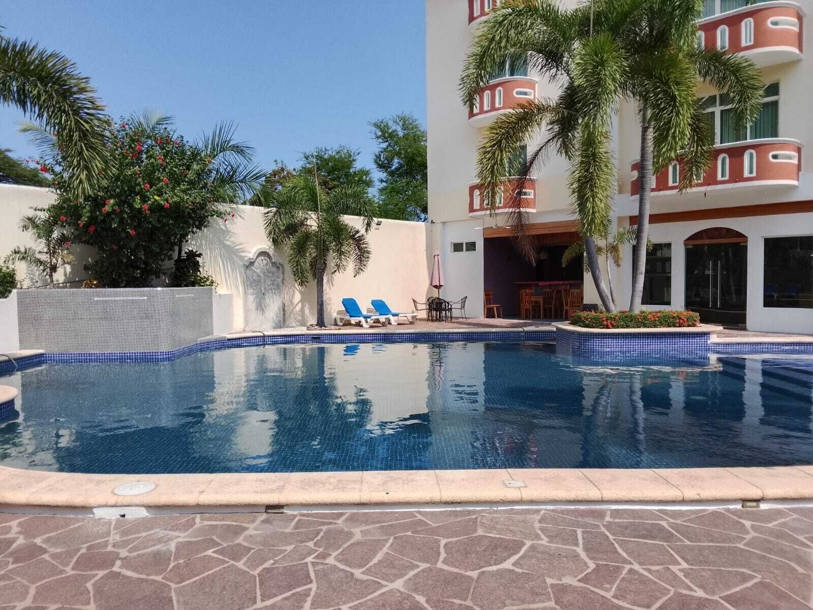 A swimming pool with lounge chairs and a patio area.