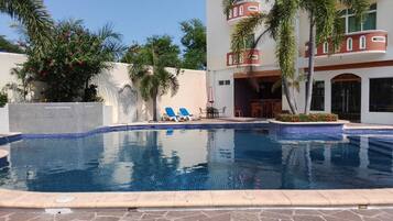 A swimming pool with lounge chairs and a patio area.