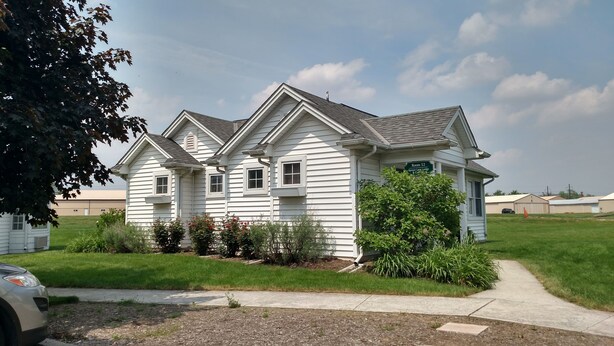 A two-story white house with a gabled roof, a front porch, and a sign indicating "Room 52." - Spruce Lane Lodge and Cottages (Lancaster)