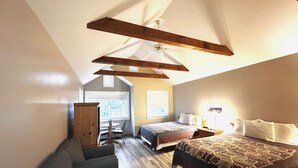 A bedroom with two beds, a wooden ceiling, a window, and a chair. - Spruce Lane Lodge and Cottages (Lancaster)