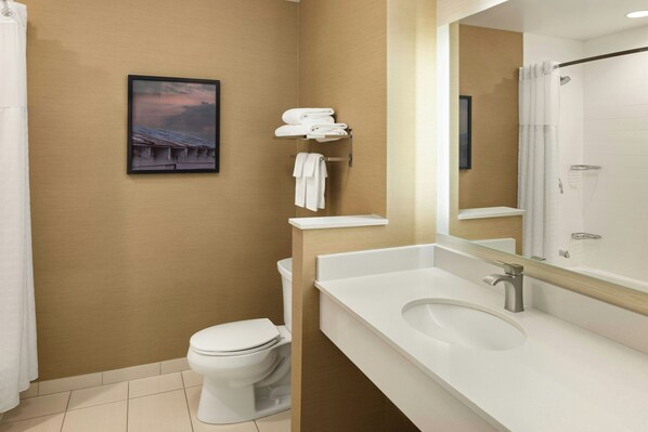 A modern bathroom with a toilet, a sink, a shower, and a towel rack.