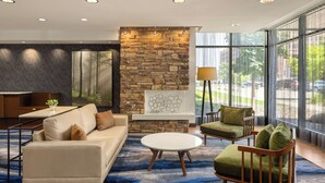 A modern living room with a stone accent wall, a sofa, a coffee table, and a chair. - Fairfield Inn & Suites by Marriott La Crosse Downtown (La Crosse)