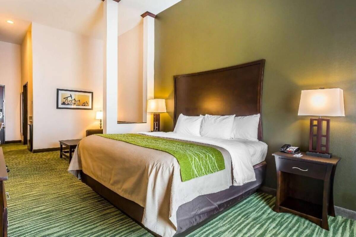 Habitación de hotel con una cama grande, dos mesitas de noche y un cuadro enmarcado en la pared.