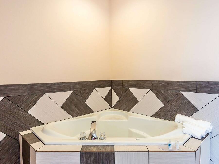 A modern bathroom with a freestanding bathtub, a vanity with a mirror, and a towel rack.