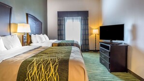 Une chambre d’hôtel avec deux lits, un téléviseur à écran plat, une commode et une fenêtre avec des rideaux.