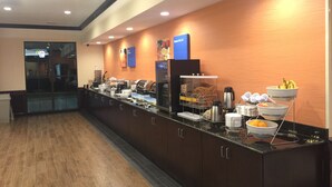 Un espace buffet avec un long comptoir, divers plats et un coin café.