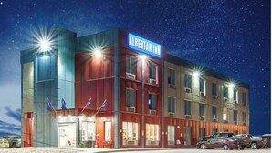 A modern hotel with a prominent sign reading "ALBERTAN INN". - Albertan Inn (Fox Creek)