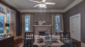 A dining room with a chandelier, a fireplace, and a view of the outdoors. - The English Merchant's Inn (Waxahachie)