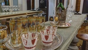 A table with various glassware, including ornate glasses and a bottle, on a tray. - The English Merchant's Inn (Waxahachie)