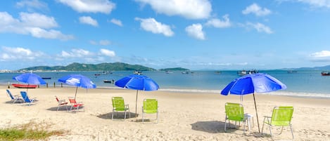 Na praia, guarda-sóis, passeios de caiaque 