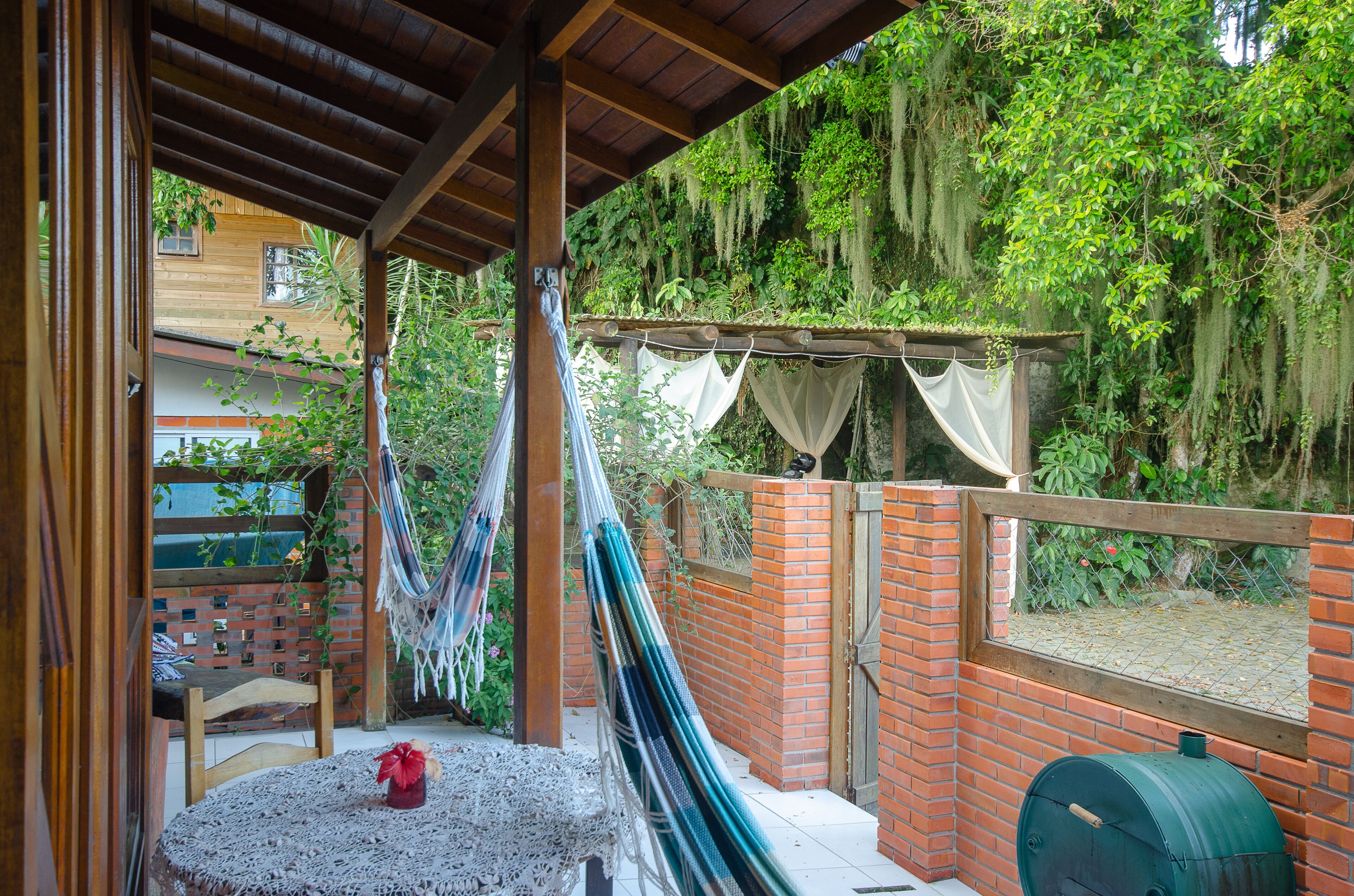 A covered patio with a table, chairs, and a hammock.