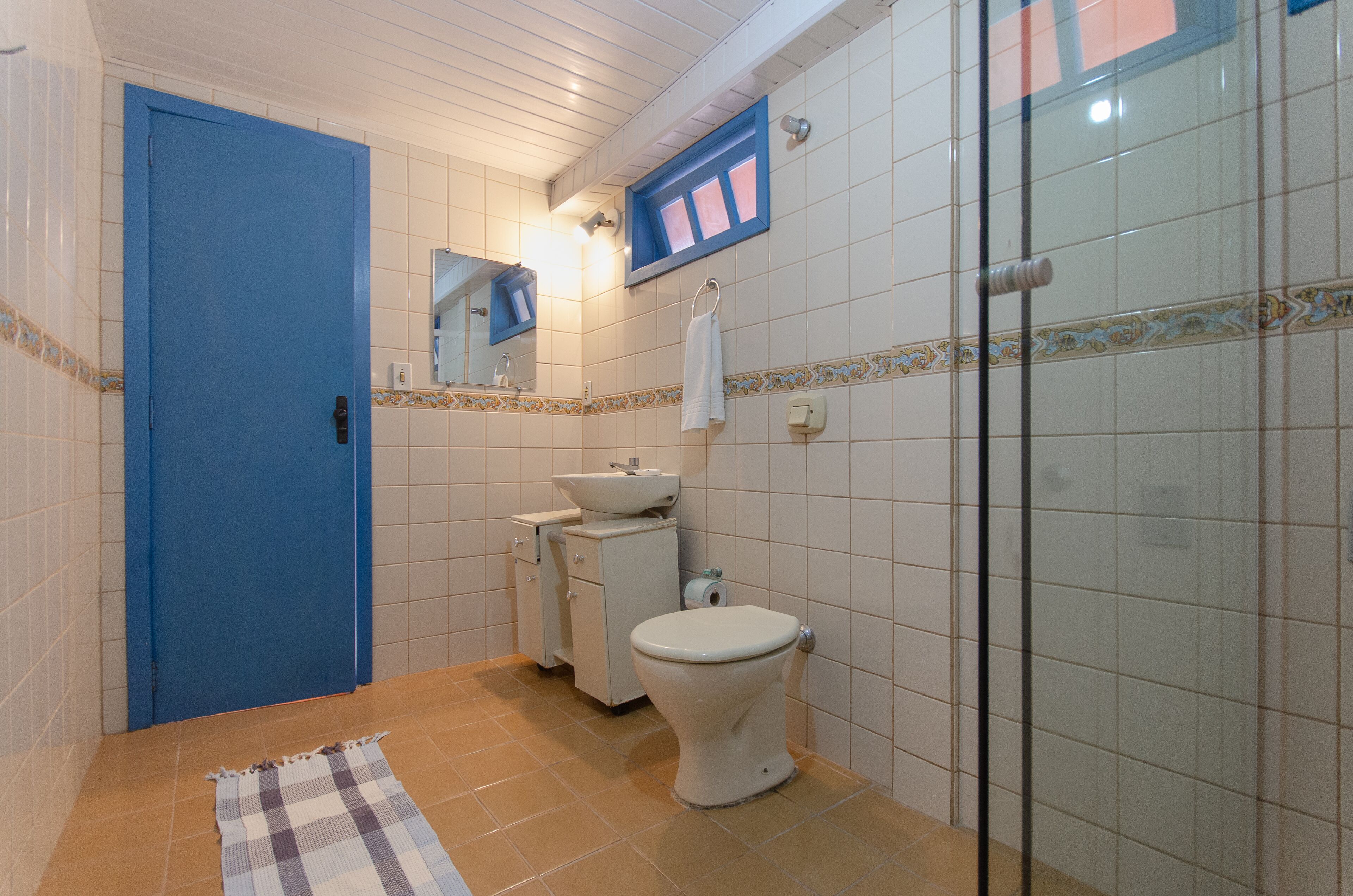 A bathroom with a blue door, white sink, and toilet.