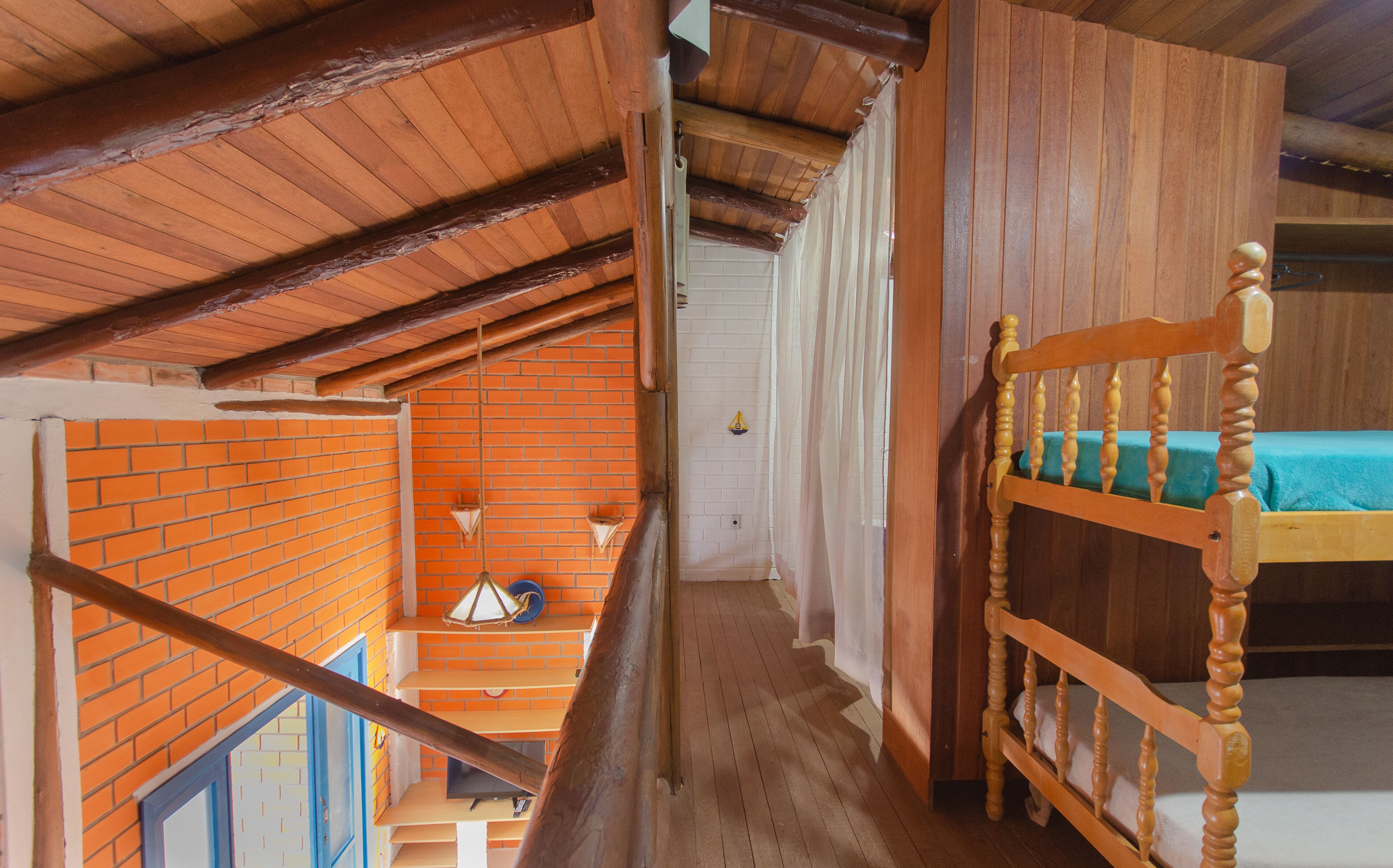 A wooden staircase leading to a loft bedroom with a bunk bed.