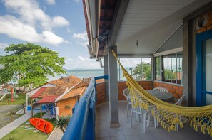 A balcony with a hammock, a view of the sea, and a playground. - Pousada Oceânica (Bombinhas)