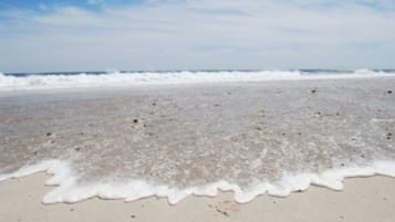 Nära stranden, vit sandstrand, parasoller och strandhanddukar