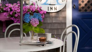 A table with a muffin, a glass, and a menu, set against a wall with a sign reading "Ship's Knees Inn".