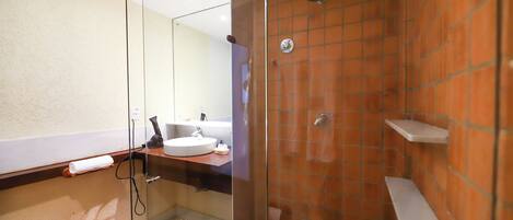 A bathroom with a glass-enclosed shower, a sink, and a towel rack.