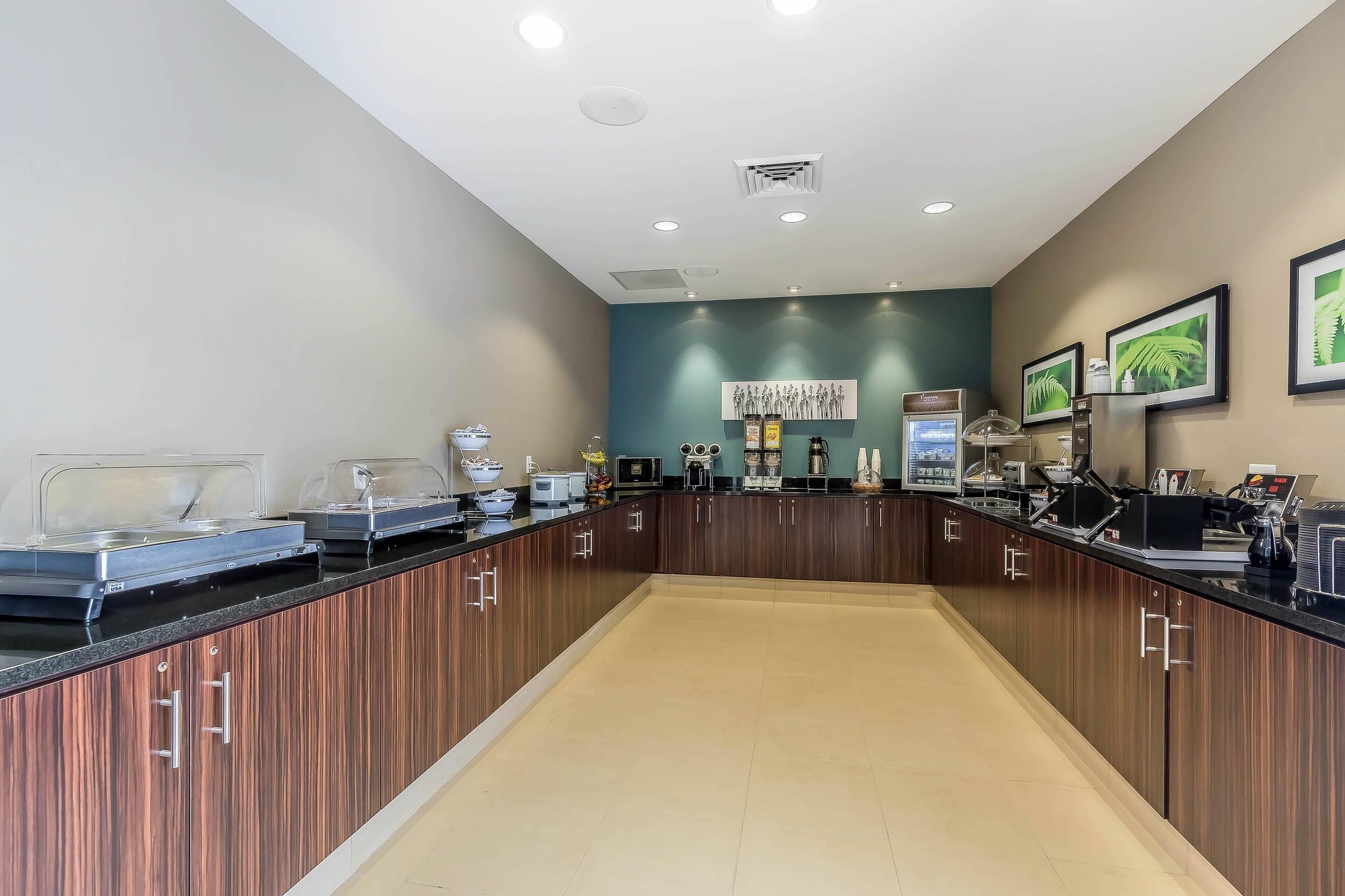 A modern kitchen with wooden cabinets, a black countertop, and various appliances.