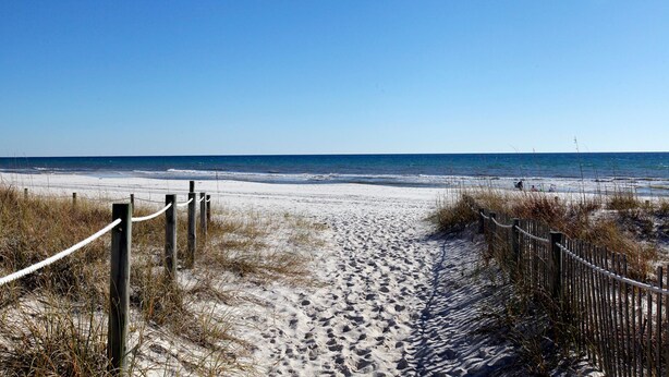 A sandy beach path with wooden posts and rope barriers leading to the ocean. - Portside Resort by Panhandle Getaways (Panama City Beach)