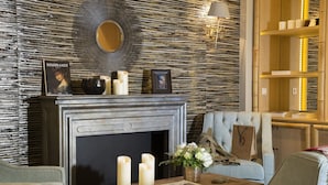 Una sala de estar con chimenea, un sofá, una mesa de centro y una estantería.