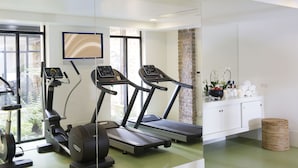 Une salle de sport moderne équipée de tapis de course, d’un vélo d’appartement et d’un rameur.