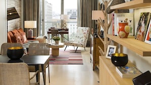 Un salon moderne comprenant un canapé, des fauteuils, une table basse et une bibliothèque.