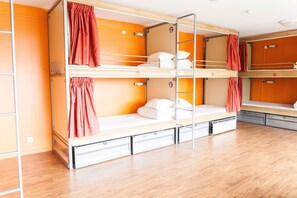 A bunk bed room with orange walls, wooden flooring, and a metal ladder. - St. Christophers Paris Canal (Paris)