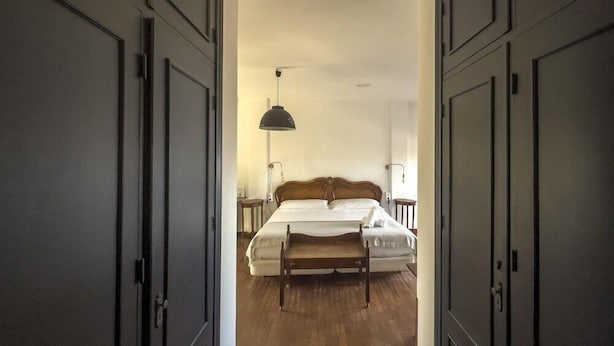 Une chambre à coucher avec un lit, des tables de chevet et une lampe suspendue.