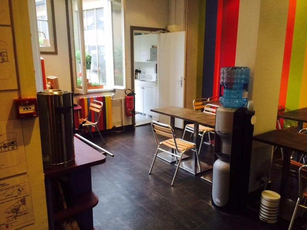 A dining area with a table, chairs, a water dispenser, and a coffee machine.