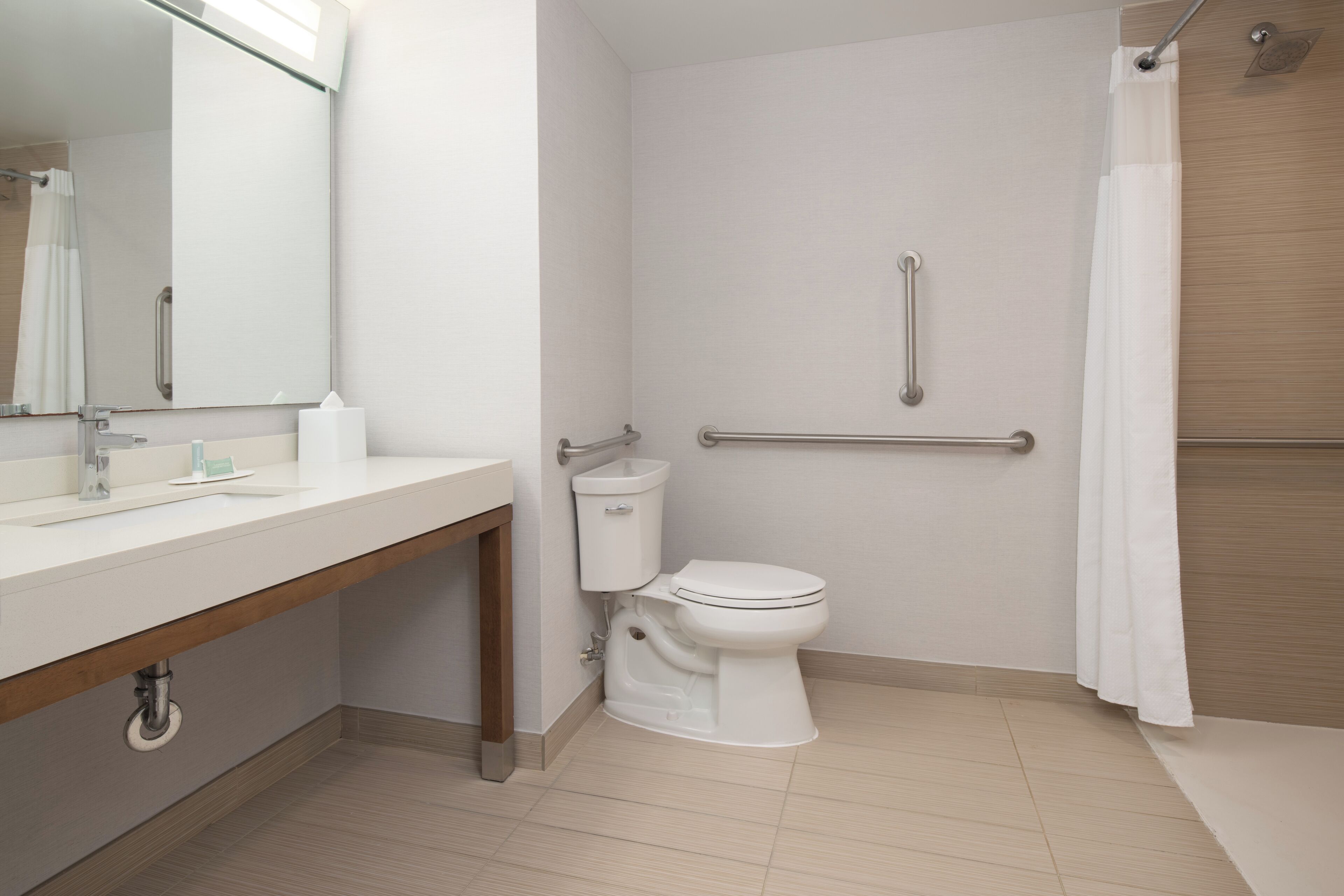 A modern bathroom with a toilet, sink, and shower area.