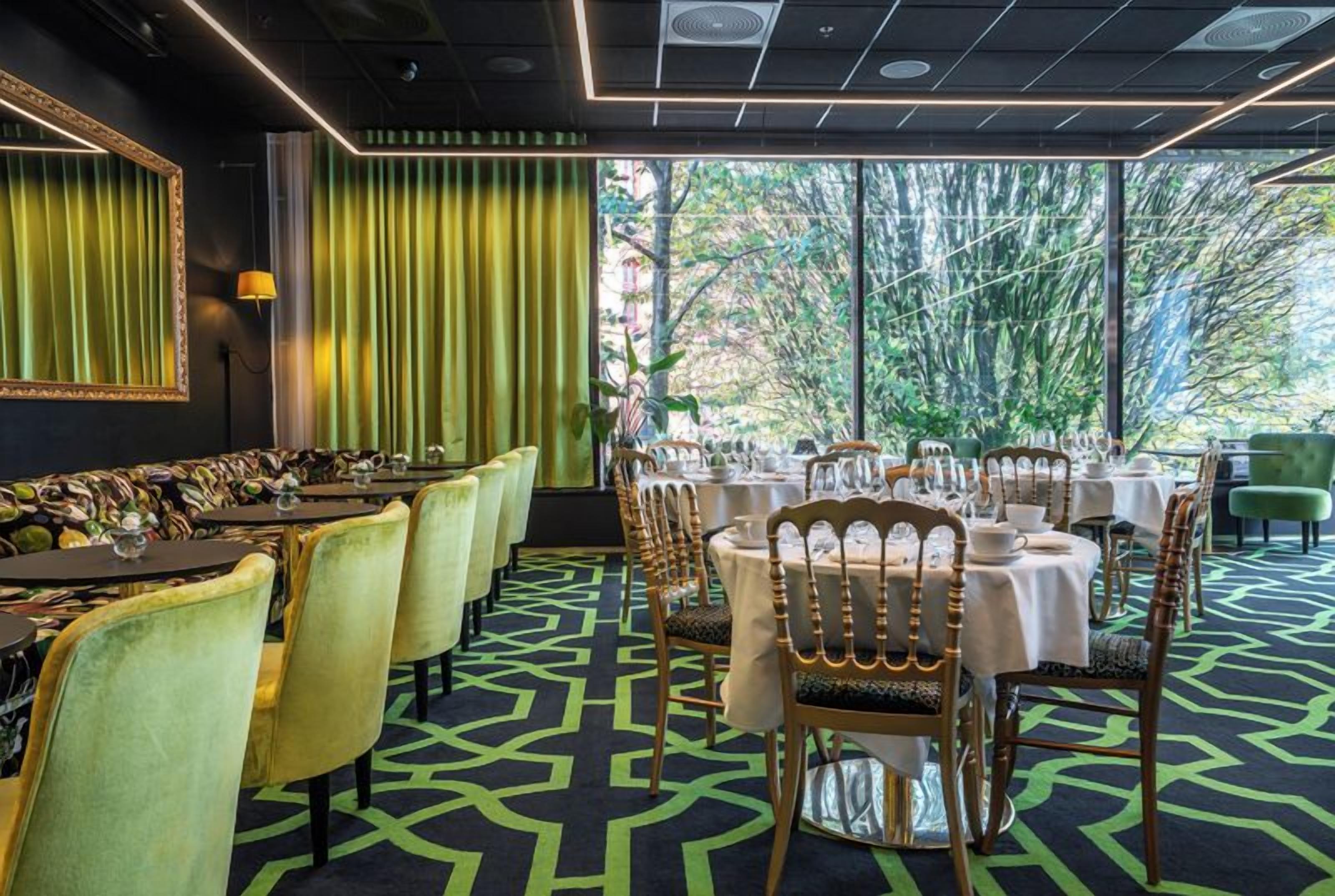 Un restaurant avec une longue table, des chaises et un sol à motifs.