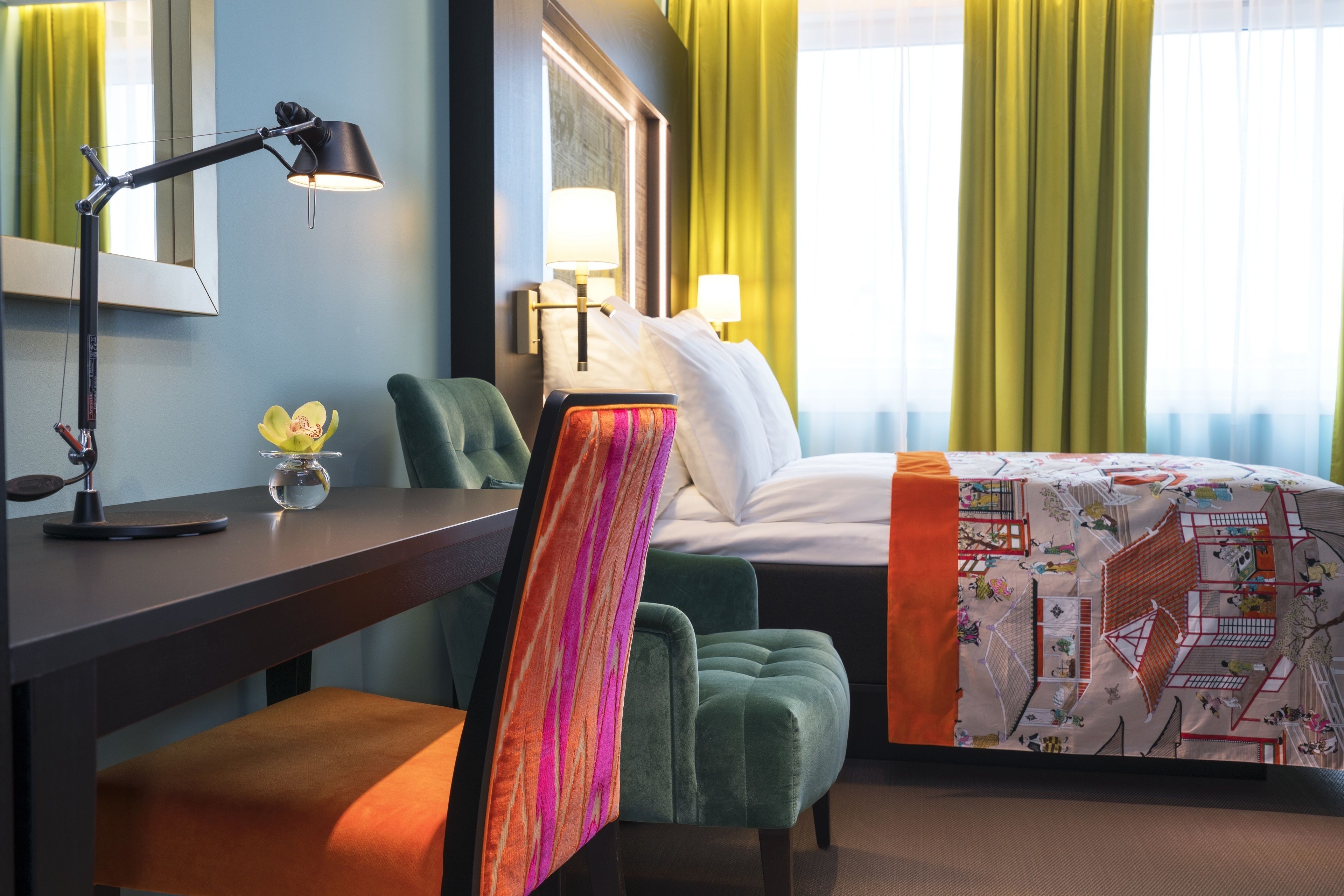Habitación de hotel con escritorio, silla, cama y vistas al exterior a través de la ventana.