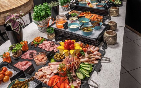 A buffet with various food items and a wooden table.