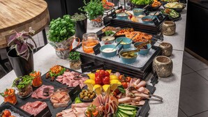 A buffet with various food items and a wooden table. - Thon Hotel Stavanger (Stavanger)