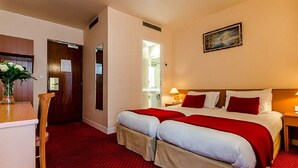 A hotel room with two beds, a desk, and a chair. - Belta Hotel Residence (PARIS)