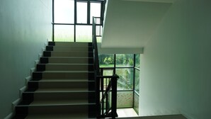 A staircase with a view of greenery outside. - NN Place (Udon Thani)