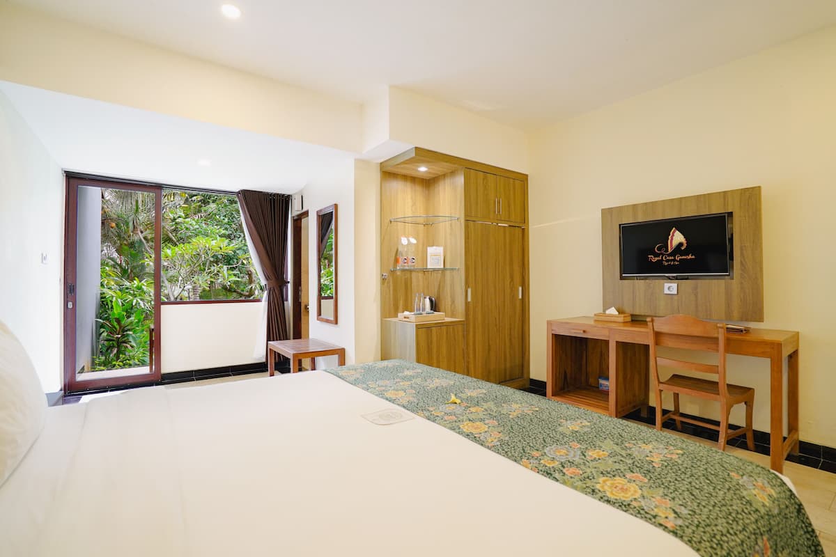A hotel room with a bed, a desk, a TV, and a wardrobe.