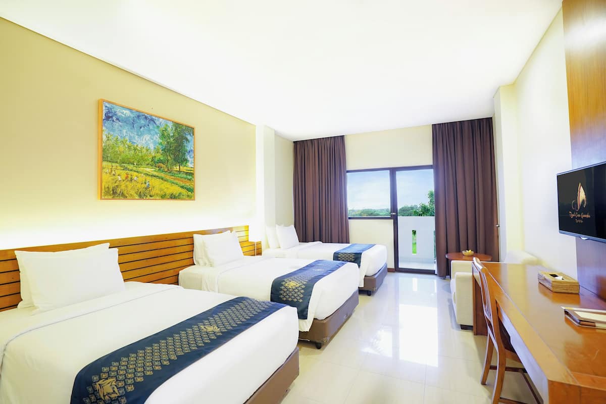 A hotel room with three beds, a TV, a dining table, and a painting on the wall.