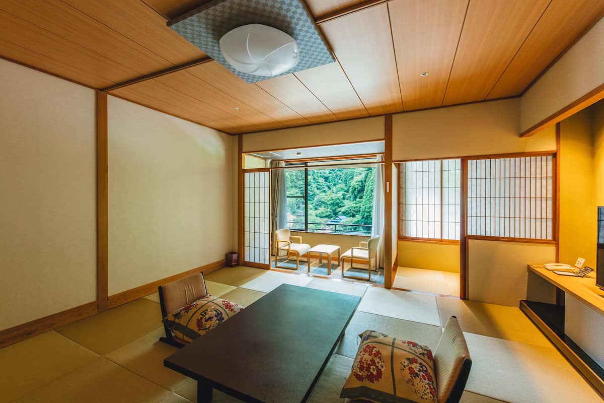 A traditional Japanese room with tatami flooring, a low table, and a sofa.