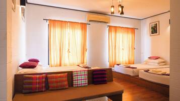 Ein Hotelzimmer mit zwei Betten, einer Bank und einem kleinen Tisch.