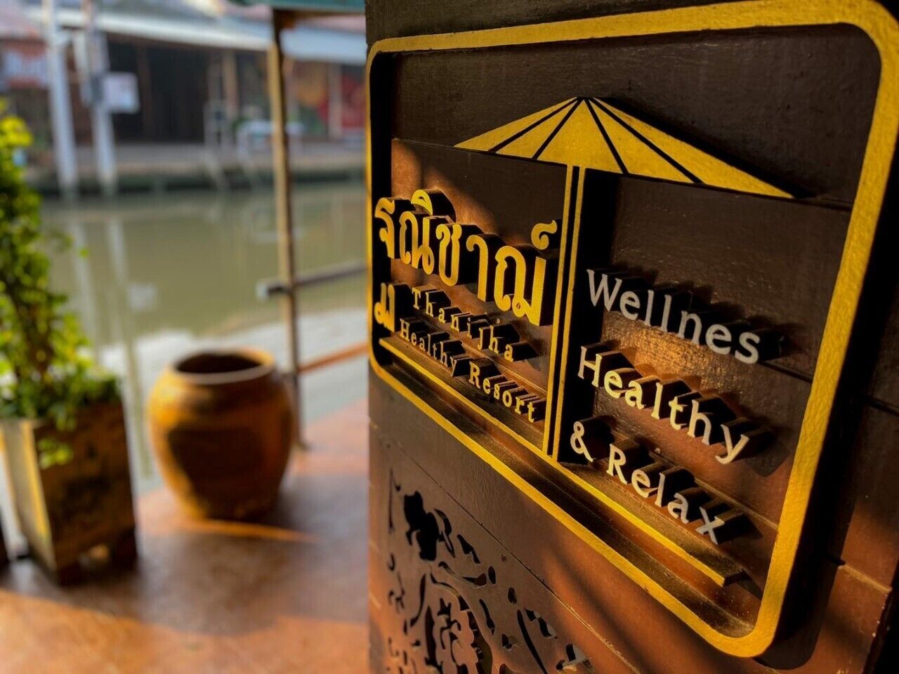 A sign with the text "Wellness & Relax" and a stylized umbrella graphic.