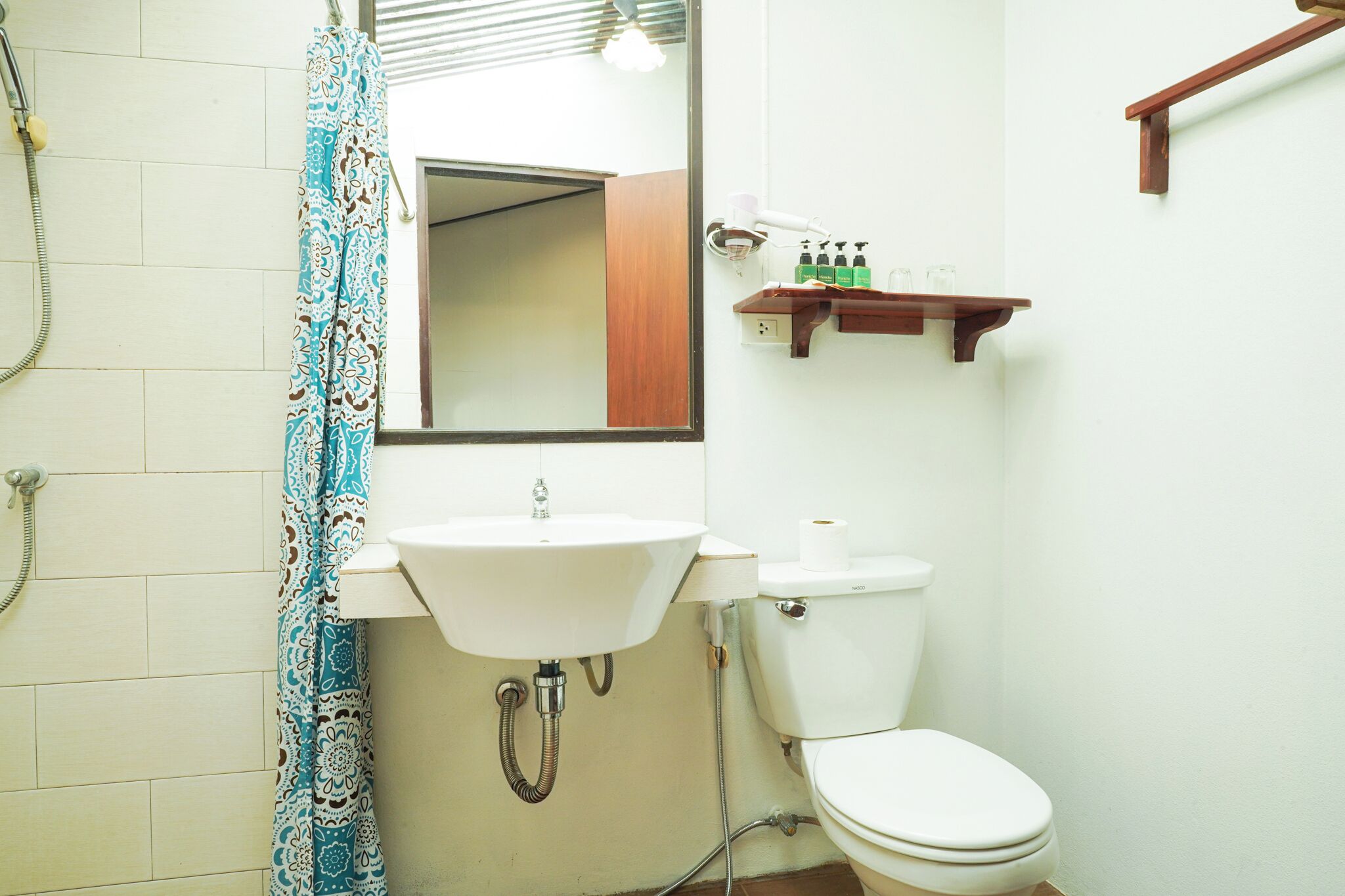 A bathroom with a white sink, toilet, and shower curtain.