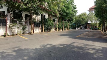 A quiet street with trees and a parked car.