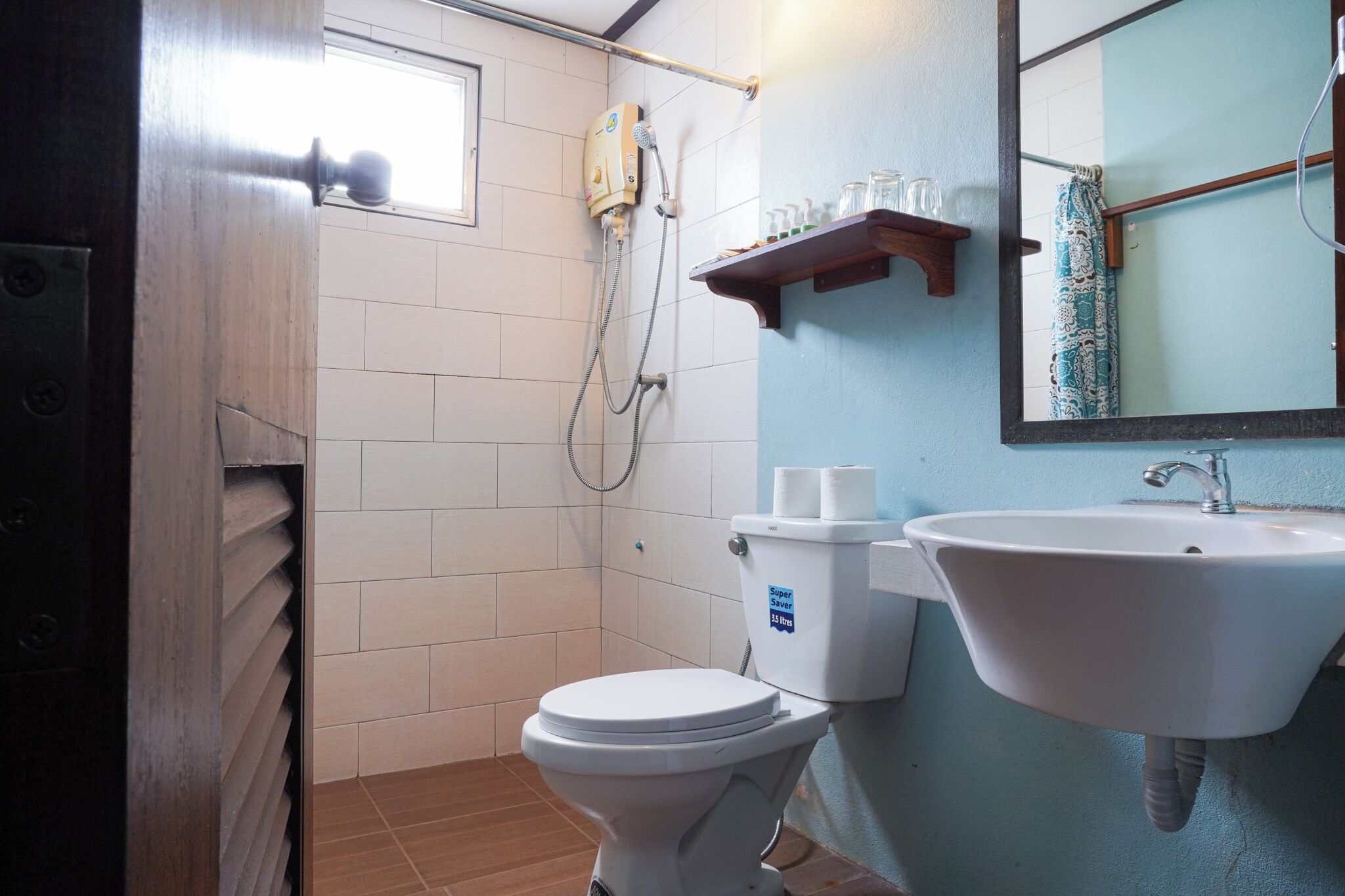 A bathroom with a toilet, a shower, and a sink.