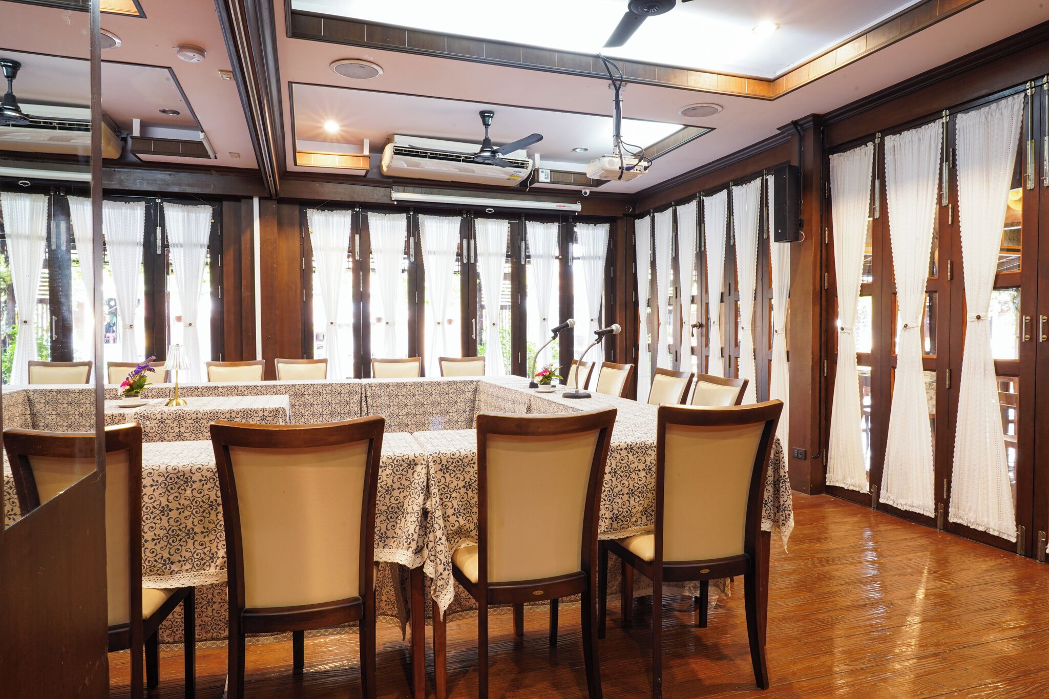 Un comedor con una mesa grande, sillas y cortinas.