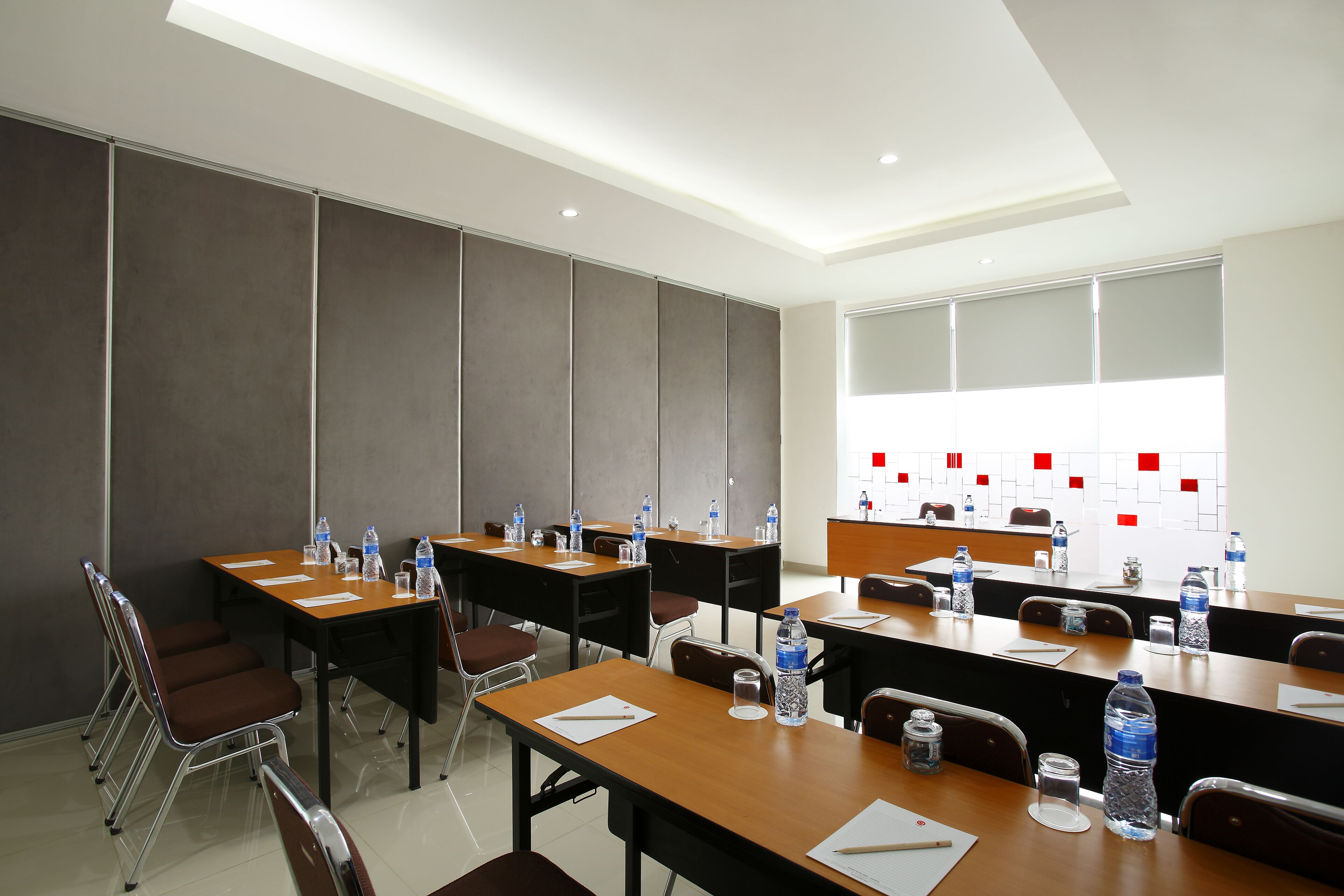 A conference room with tables, chairs, and water bottles.