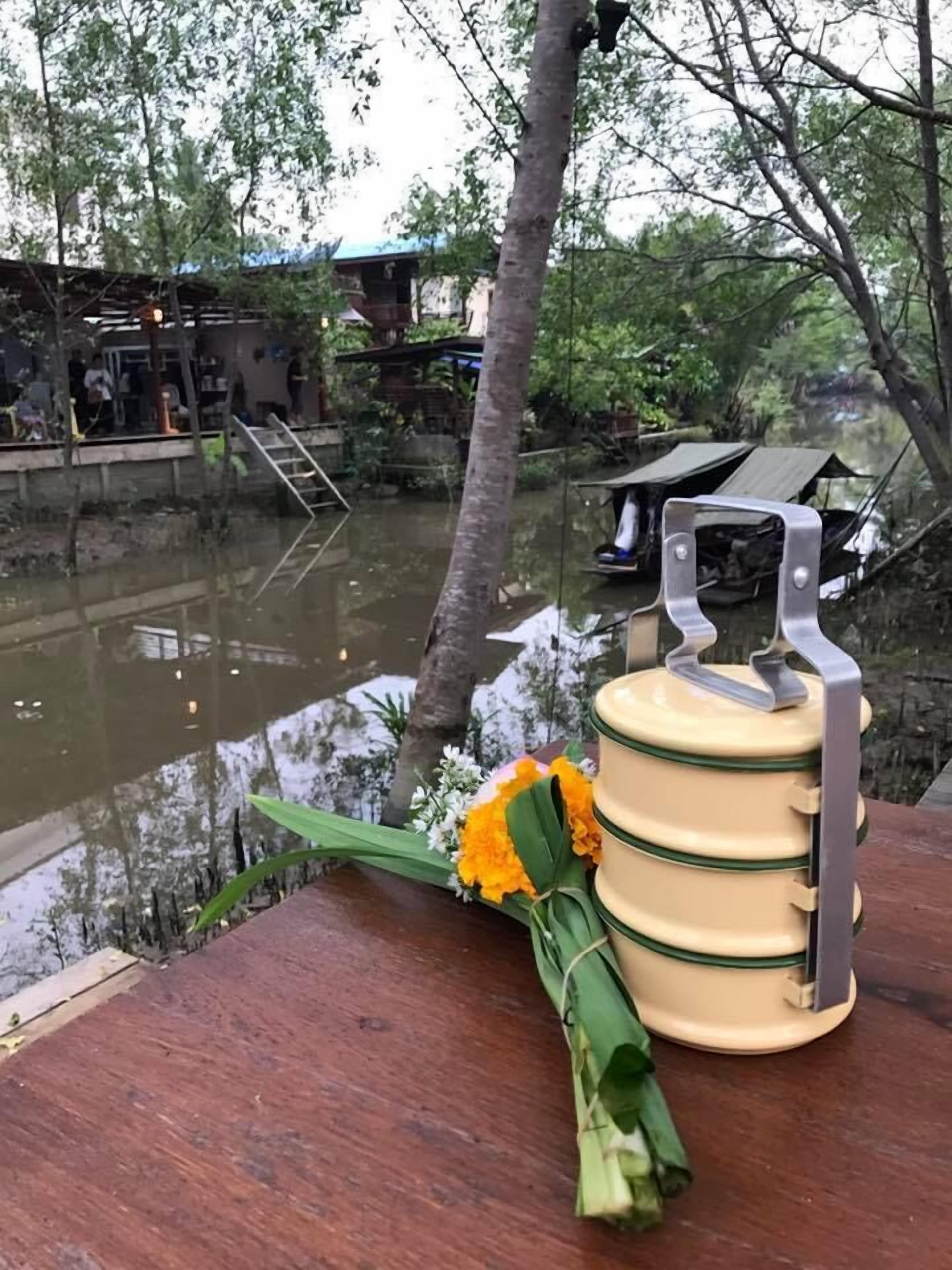 Een houten tafel met een waterkruik en een bloemenboeket.