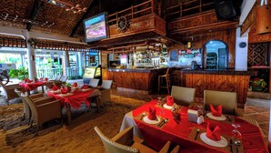 Een restaurant met houten inrichting, een bar en gedekte tafels.