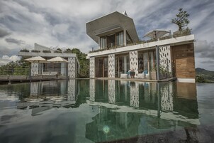 Un hotel moderno con piscina, zona de estar al aire libre y un diseño arquitectónico único.