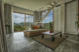 Una sala de estar moderna con un sofá, una mesa de centro y una escalera.